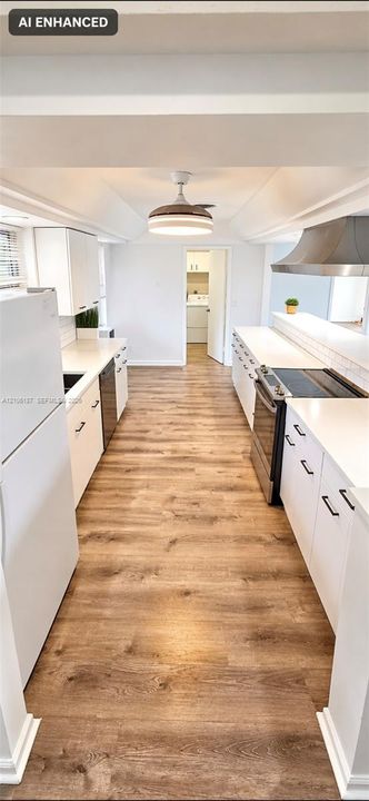 Kitchen featuring white cabinetry, solid-surface countertops, wood-finish flooring, a stainless steel range hood, and a ceiling-mounted light fixture
