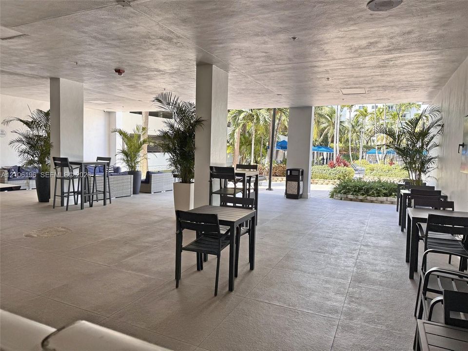 Covered outdoor terrace featuring large-format tile flooring and structural support columns