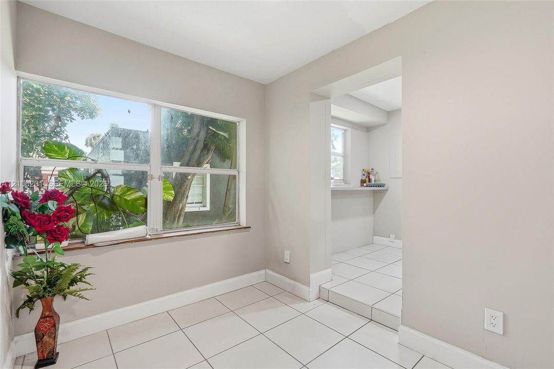 Light-filled room featuring large horizontal windows, ceramic tile flooring, and a built-in pass-through ledge