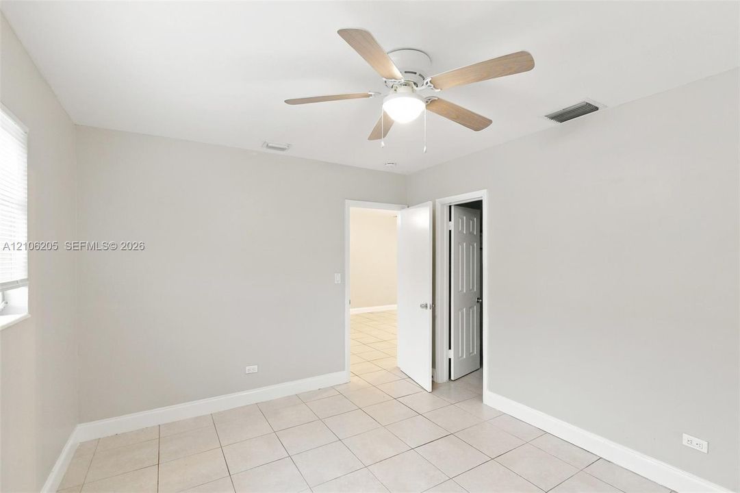 Interior room featuring neutral wall paint, tile flooring, and a ceiling fan with integrated light fixture