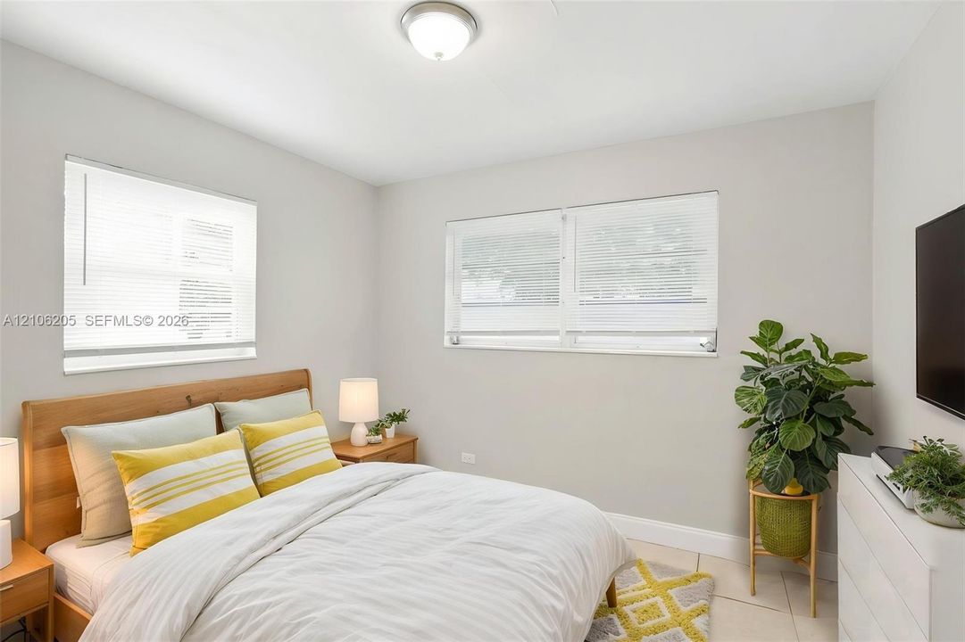 Neutral wall paint, two dual-pane windows with integrated blinds, tile flooring, and a flush-mount overhead light fixture
