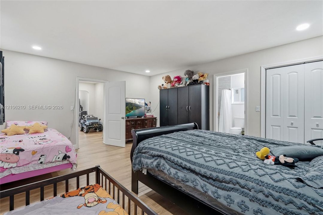 Room featuring wood-finish flooring, recessed lighting, and double-panel doors leading to a closet