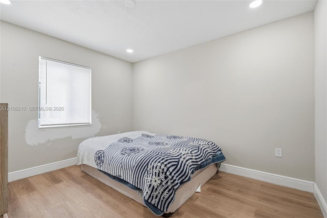 Neutral wall color, wood-finish flooring, and recessed ceiling lighting