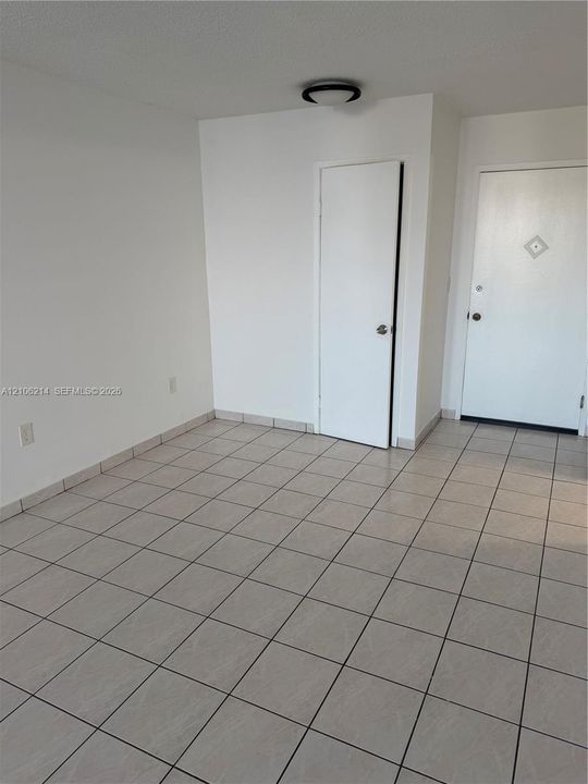 Neutral-toned ceramic tile flooring, solid-core interior doors, and low-profile flush-mount ceiling lighting
