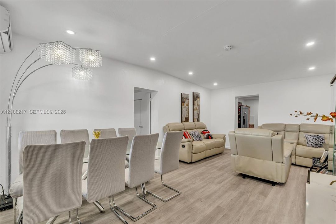 Wood-finish flooring, recessed lighting, and multi-arm crystal-style overhead lighting