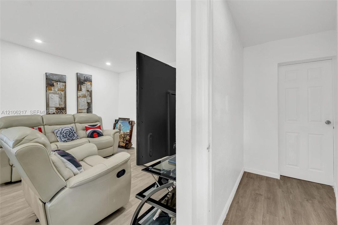 Interior space featuring recessed lighting, wood-finish flooring, and a six-panel interior door