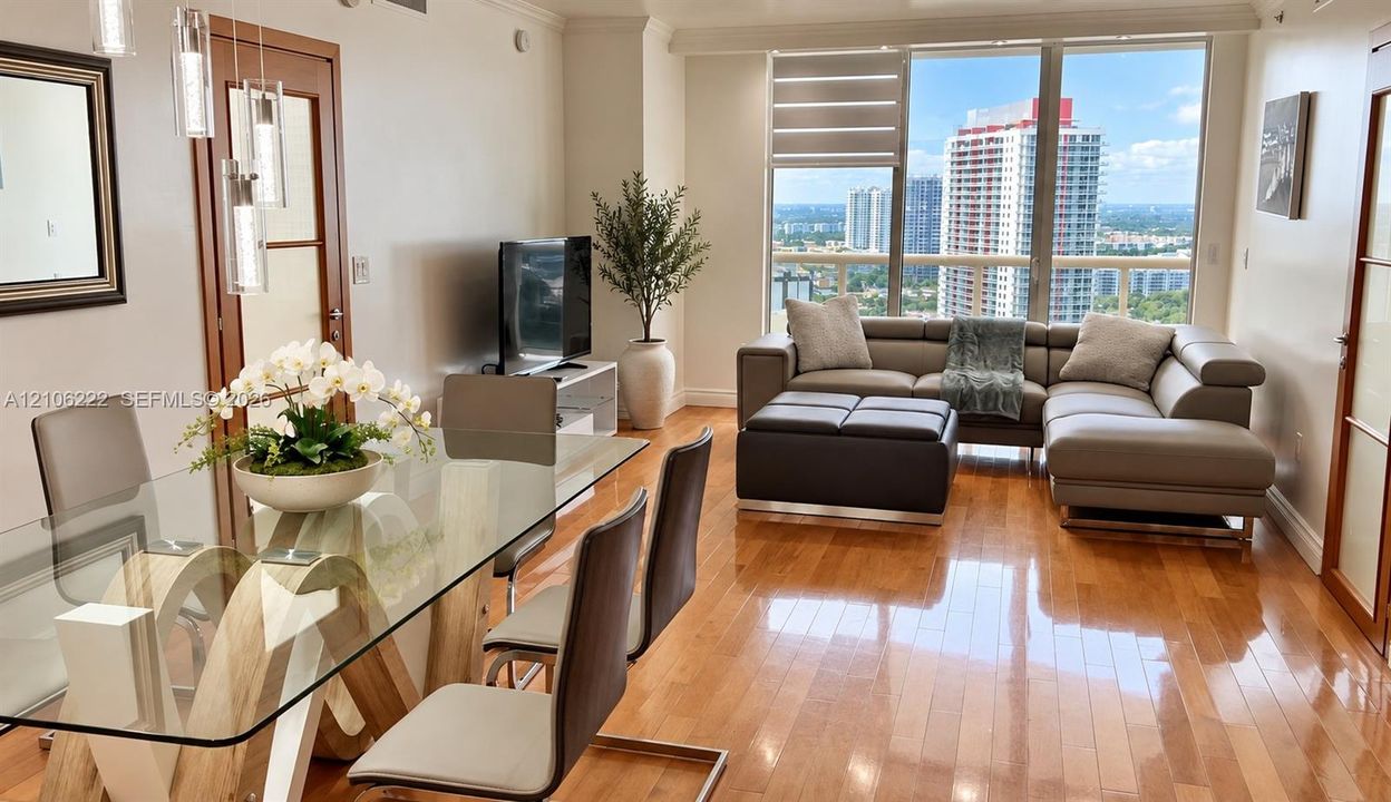 Open-concept interior featuring wood-finish flooring, floor-to-ceiling windows, and wood-framed glass-paneled interior doors