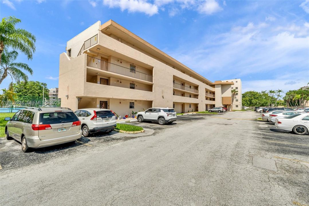 Multi-level stucco exterior featuring private balconies and surface parking