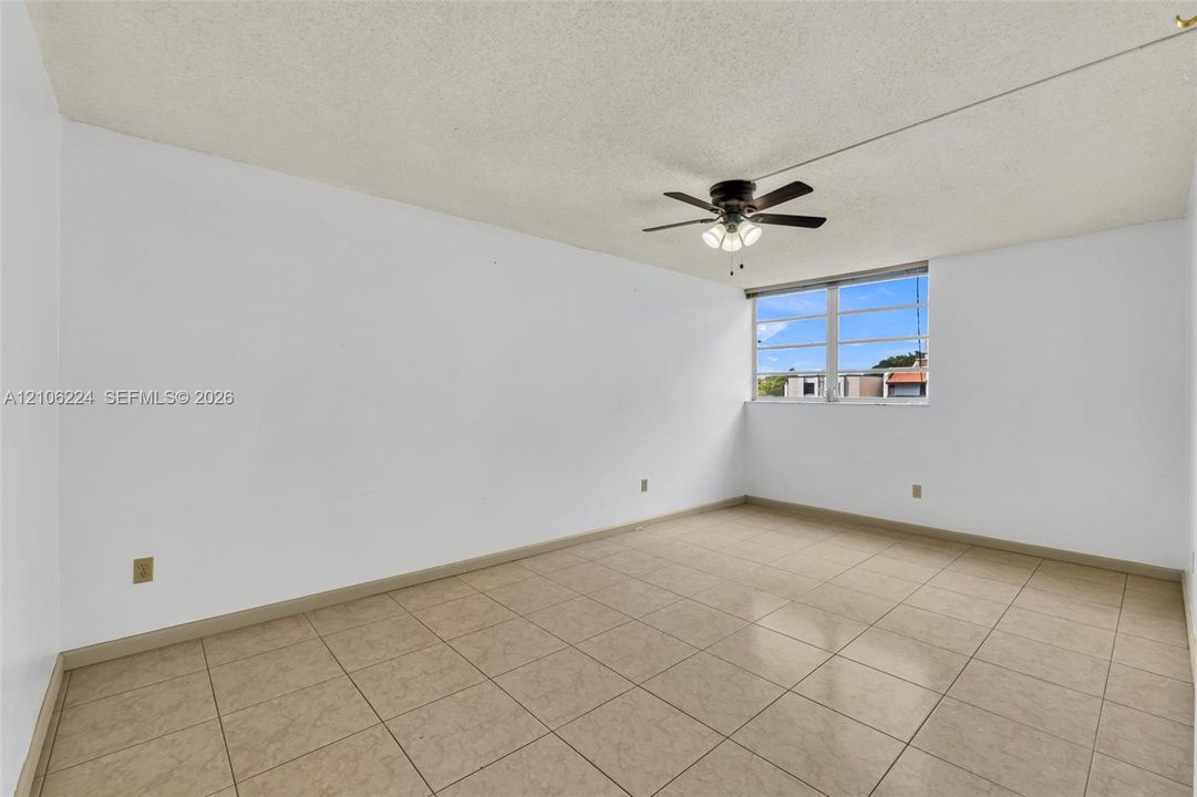 Interior space featuring tile flooring, a multi-pane window, and a ceiling fan with integrated lighting