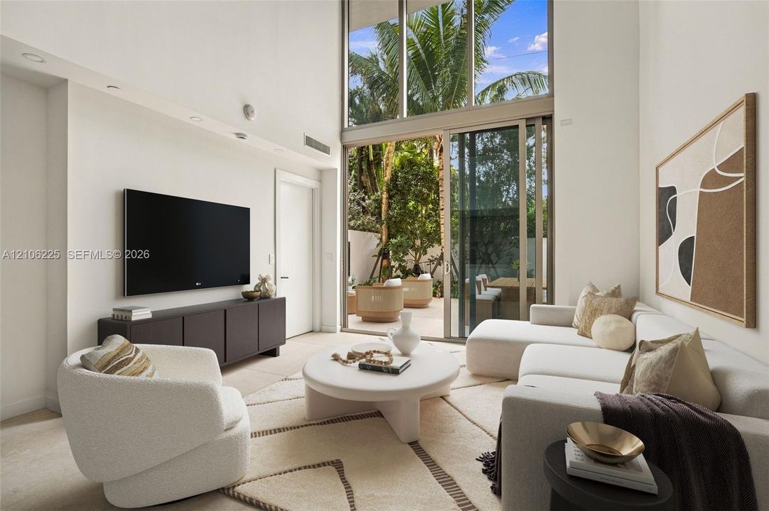 Double-height ceilings, floor-to-ceiling windows, and expansive sliding glass doors providing outdoor access