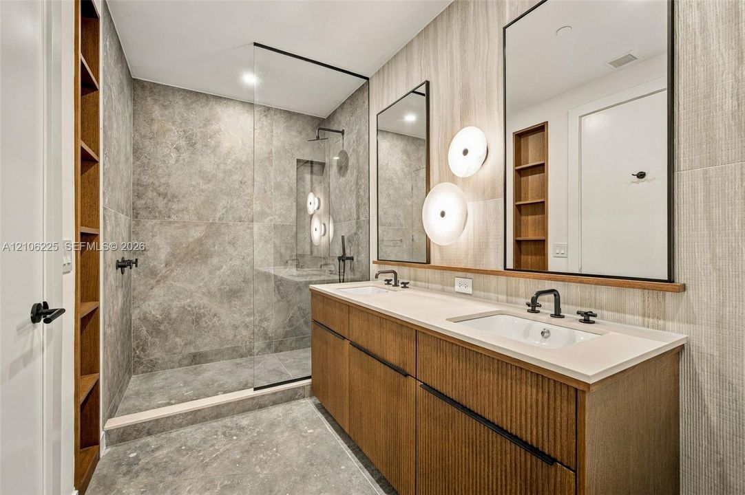 Custom vanity with a solid-surface countertop, integrated dual sinks, and matte black widespread faucets