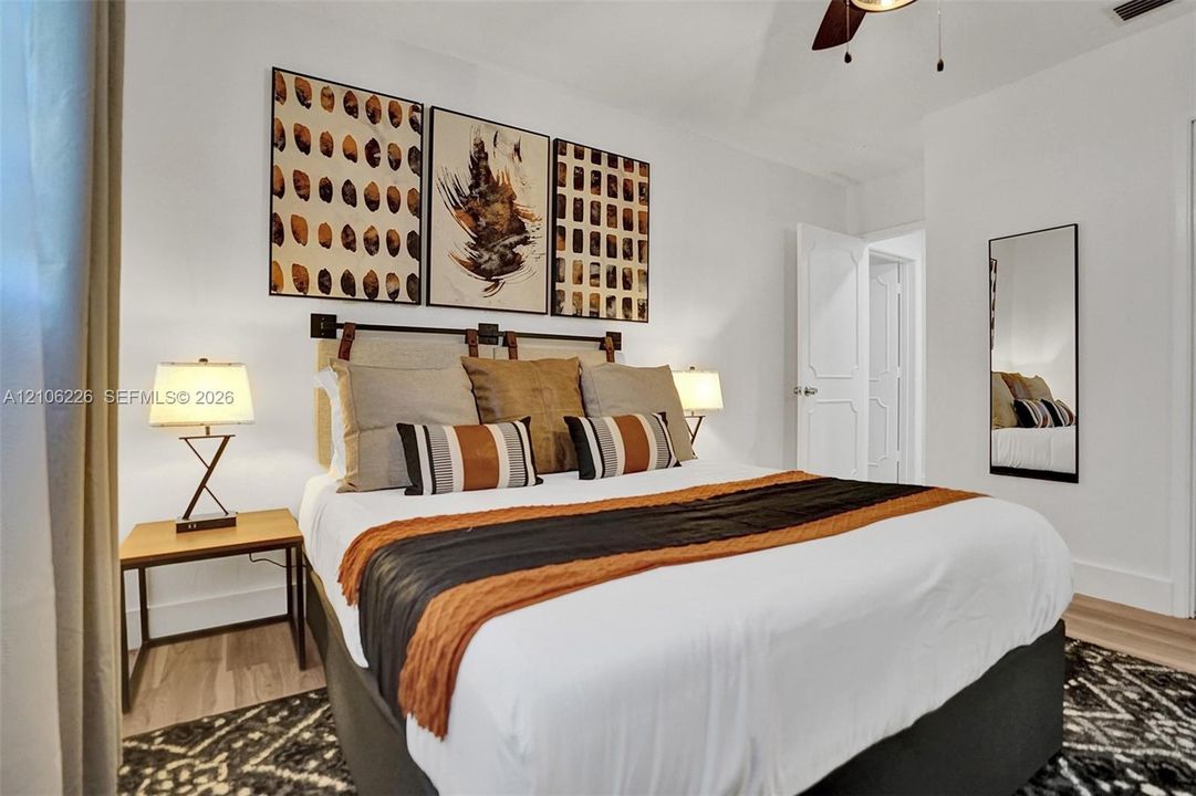 Vaulted ceiling with attached multi-blade ceiling fan and neutral interior wall finish