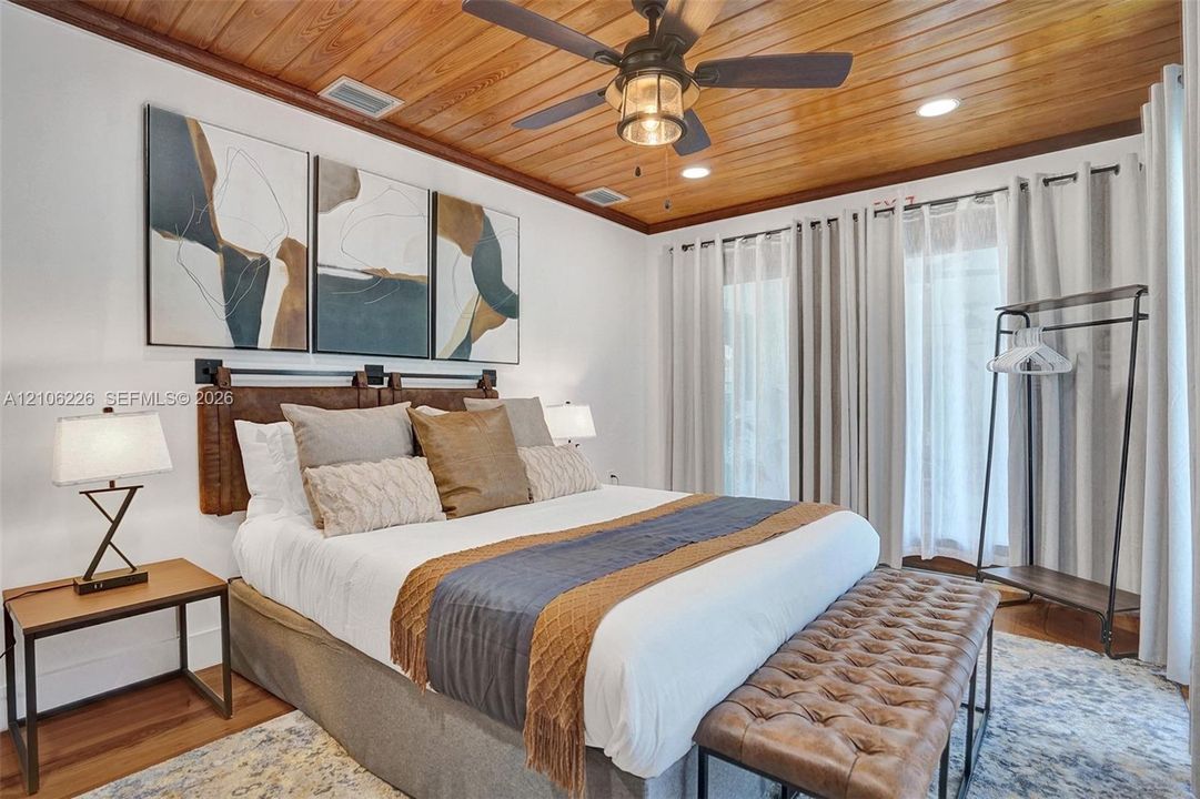 Vaulted wood-plank ceiling featuring an integrated metal-and-glass ceiling fan with recessed lighting