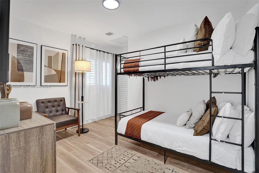Neutral-toned wood-finish flooring, white walls, and interior window shutters