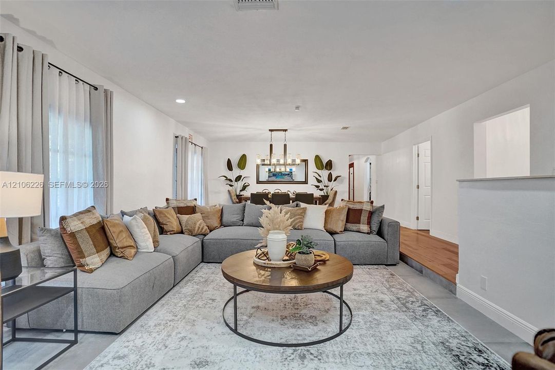 Open-concept interior featuring recessed lighting, a modern multi-light chandelier, and wood-finish flooring