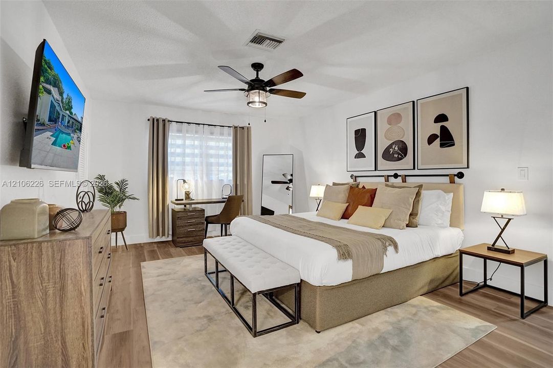 Wood-finish flooring, neutral walls, and a ceiling fan with integrated lighting