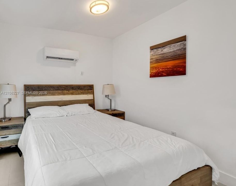 Wall-mounted ductless air conditioning unit, ceiling-mounted dome light fixture, and neutral wall finish
