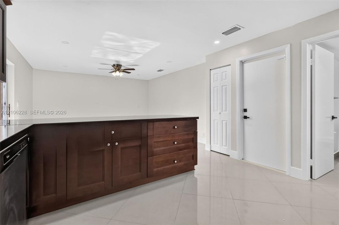 Kitchen featuring dark wood-finish cabinetry, a dark countertop, recessed lighting, a ceiling fan, and tile flooring