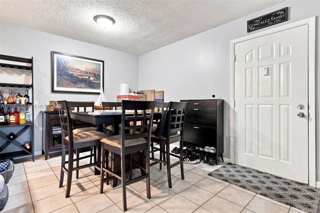 Ceramic tile flooring, white six-panel entry door, and flush-mount ceiling lighting