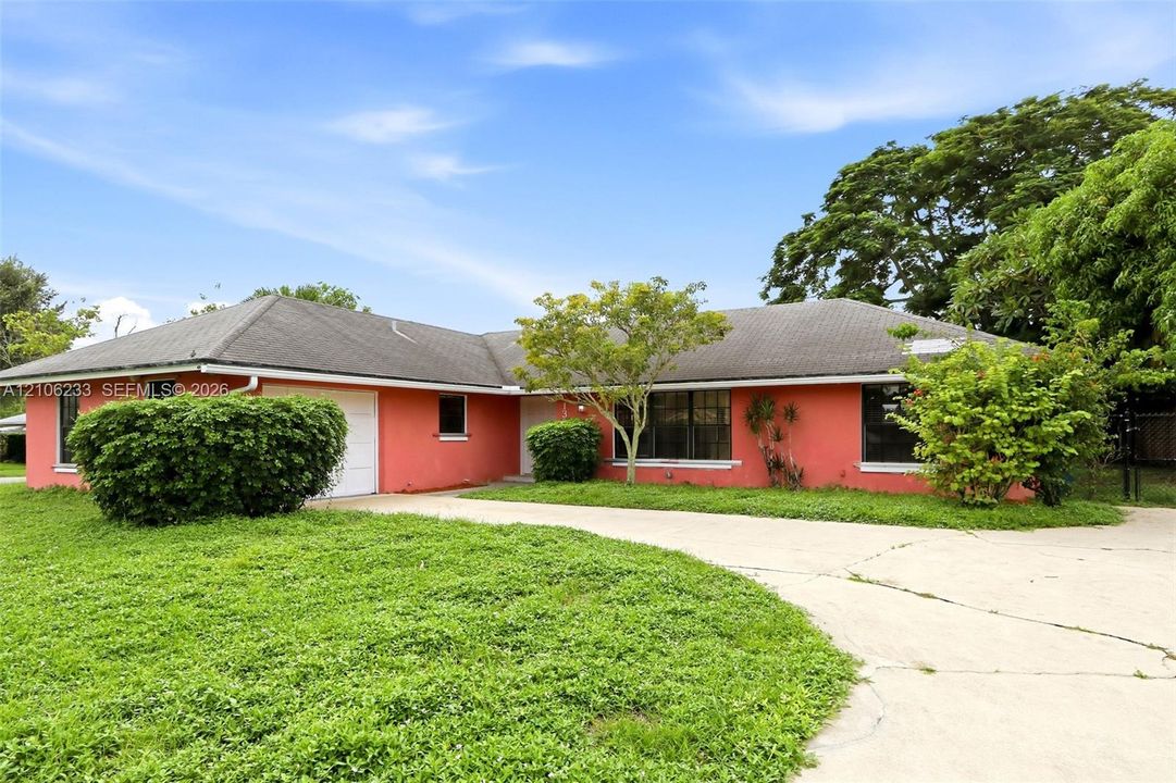 Single-story exterior featuring a hip roof, a concrete driveway, and an attached garage