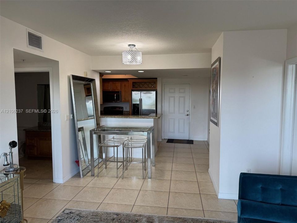 Kitchen featuring a breakfast bar, wood cabinetry, built-in microwave, and tile flooring