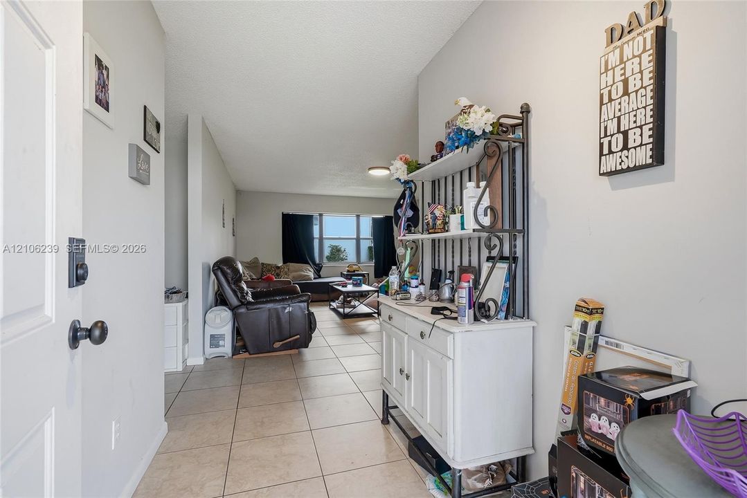 Interior space featuring large-format ceramic tile flooring and a prominent window providing natural light