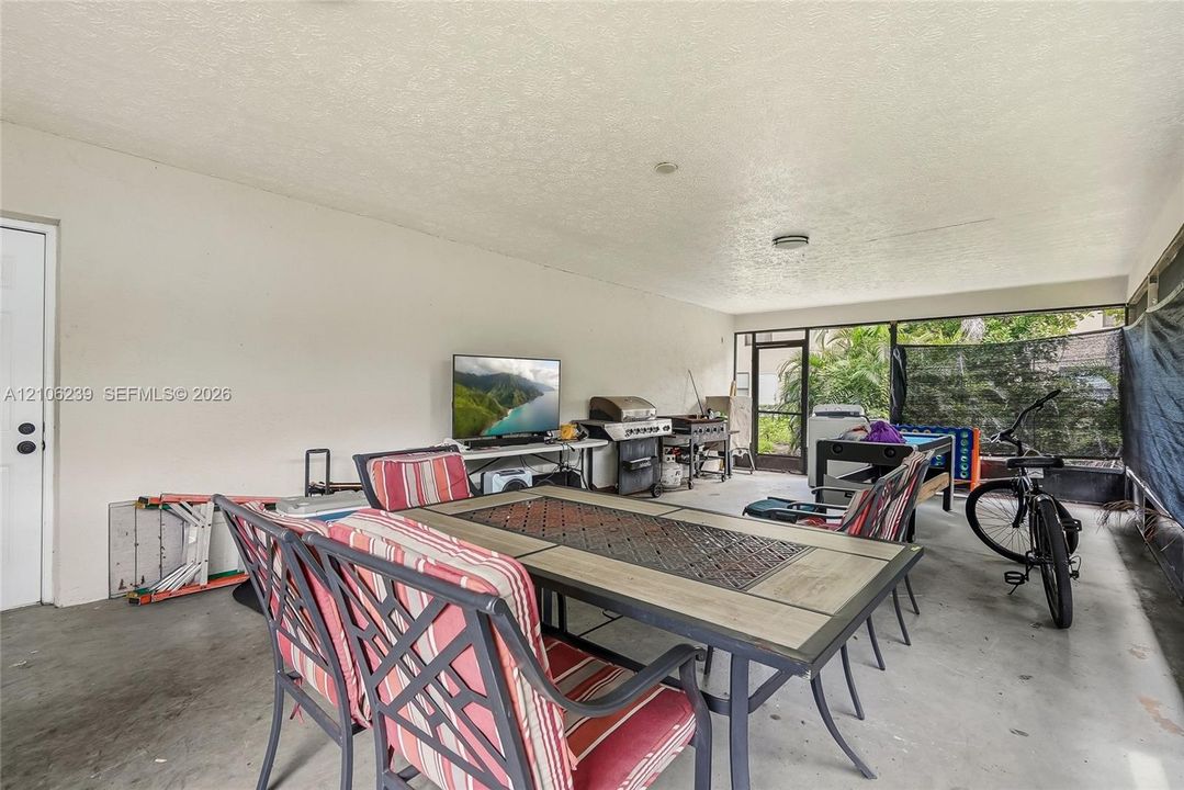 Screened lanai featuring concrete flooring, a covered ceiling, and a secure door entry