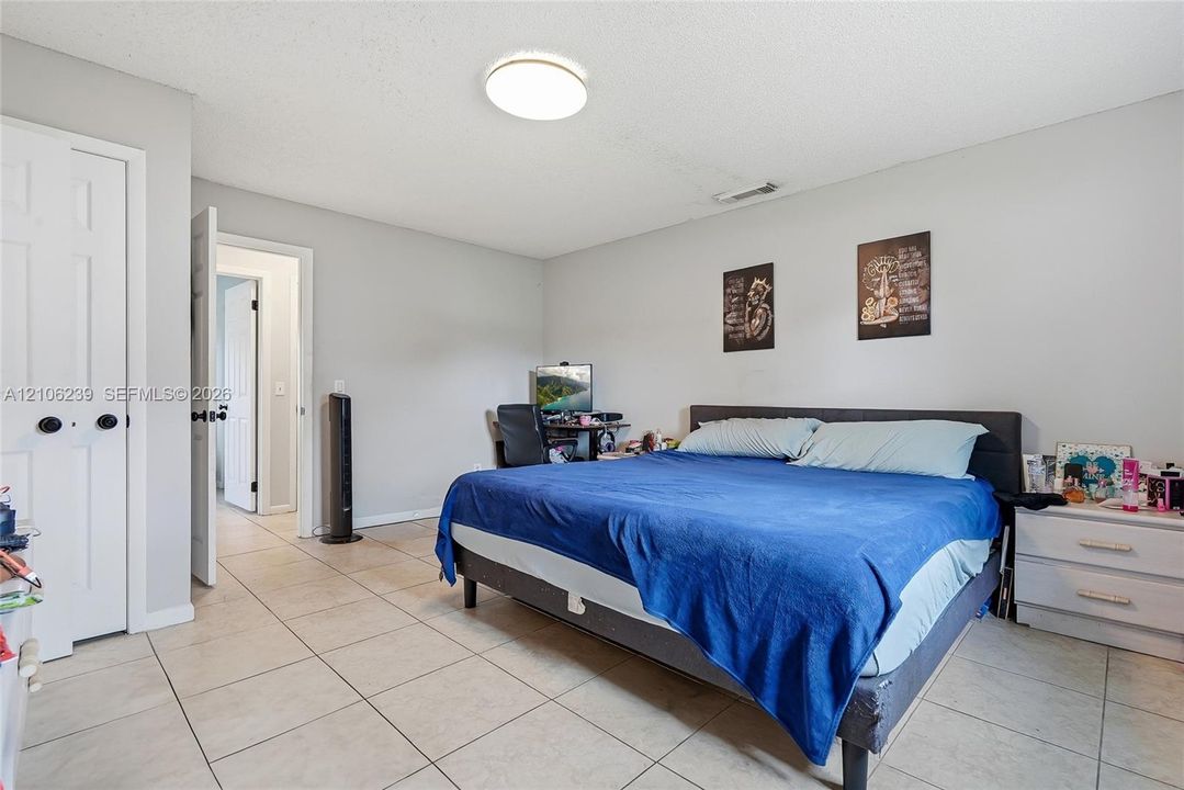 Interior room featuring light-toned tile flooring, neutral wall paint, and a white six-panel closet door