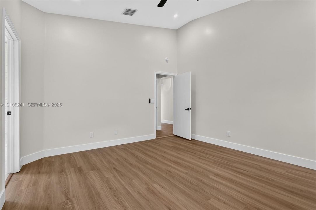 Interior space featuring high ceilings, wood-finish flooring, recessed lighting, and matte black door hardware