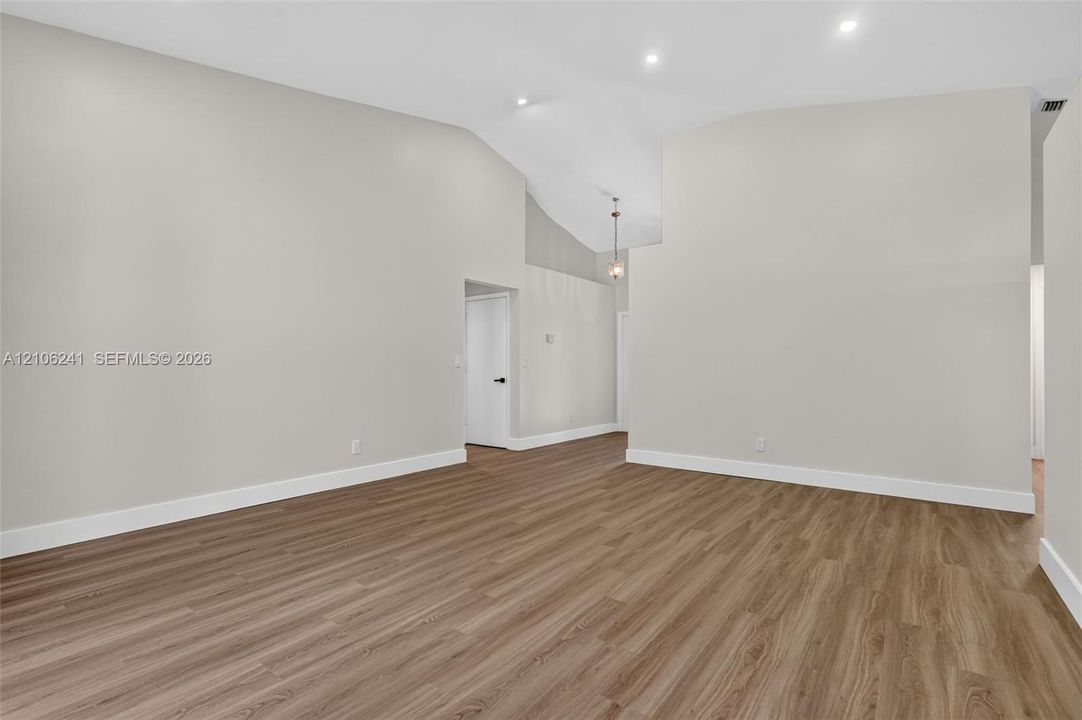 Interior space featuring vaulted ceilings, recessed lighting, and wood-finish flooring