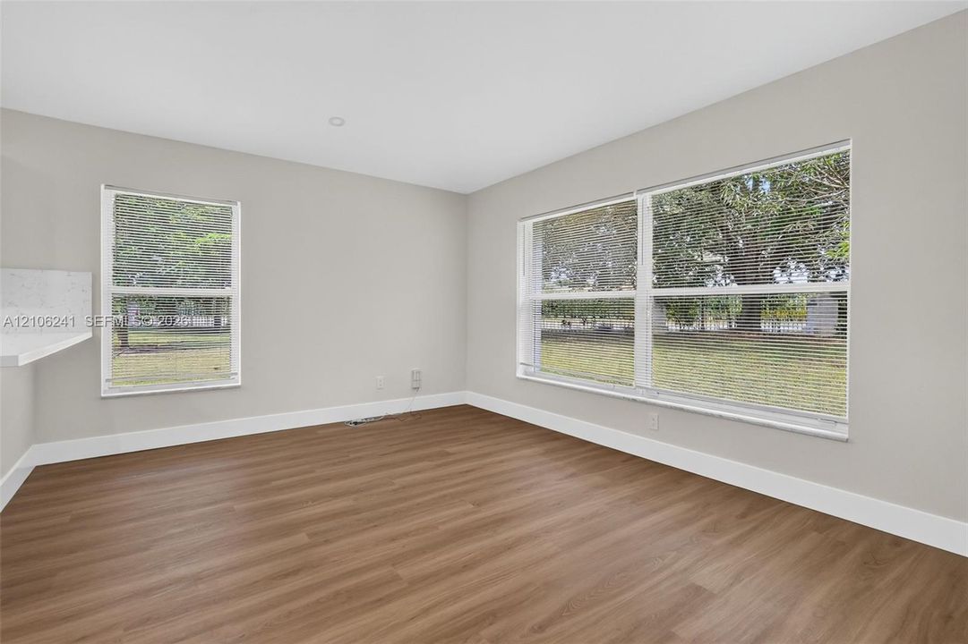 Neutral-toned interior space featuring wood-finish flooring, recessed lighting, and expansive windows