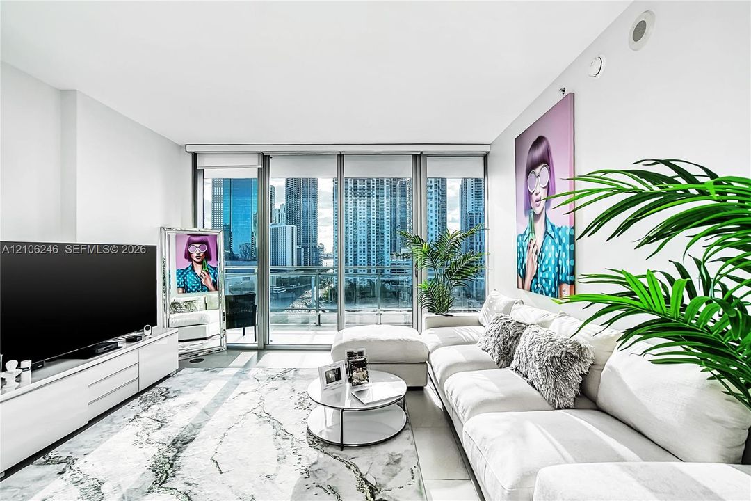 Floor-to-ceiling glass paneling, high-rise urban landscape, light-reflecting tile flooring, and custom white built-in media console