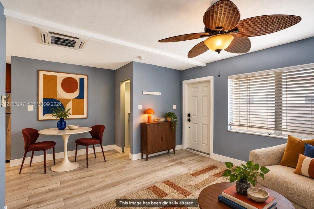 Wood-finish flooring, ceiling fan with integrated lighting, multi-panel door, and window with horizontal blinds