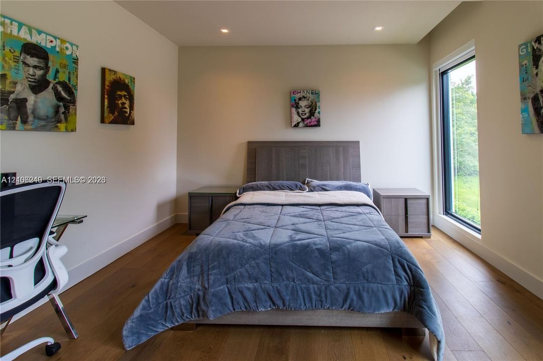 Wood-finish flooring, recessed ceiling lighting, and a tall vertical window