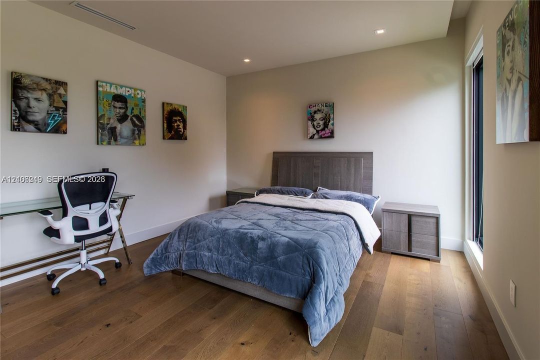 Wood-finish flooring, recessed lighting, and expansive floor-to-ceiling windows