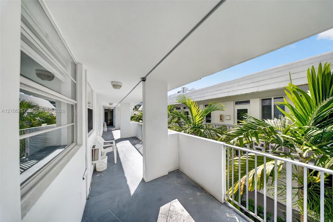 Front entrance Balcony: Covered balcony featuring stone-finish flooring, metal railing, and surface-mounted ceiling lighting