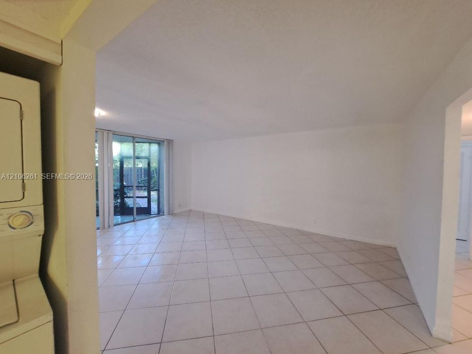 Open-concept interior featuring large-format diagonal tile flooring and sliding glass doors leading to a screened enclosure