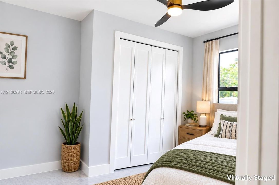 Neutral wall palette with white bi-fold closet doors, multi-pane window, and integrated matte black ceiling fan with light fixture