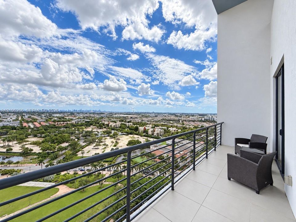 Covered balcony with large-format tile flooring and metal railing