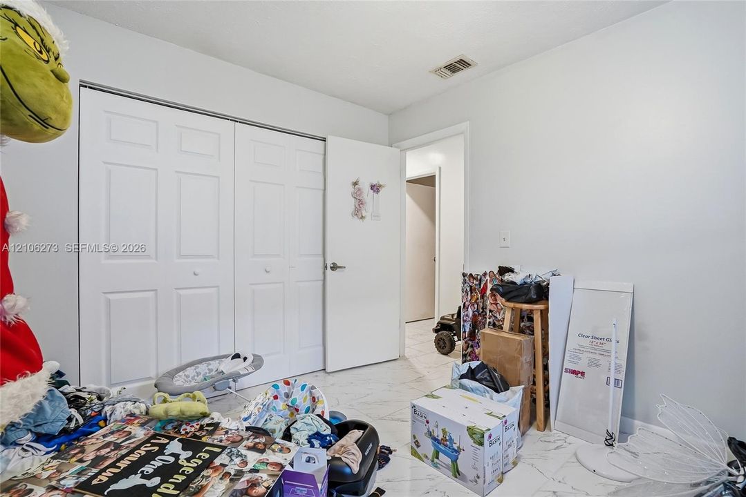 Interior space featuring white tile flooring and dual-panel closet doors