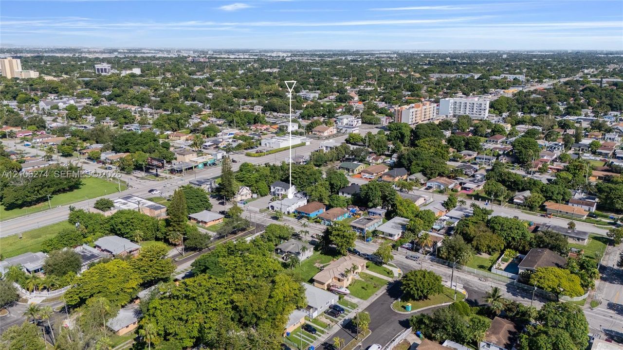 Aerial perspective of residential property featuring a dedicated driveway and mature trees