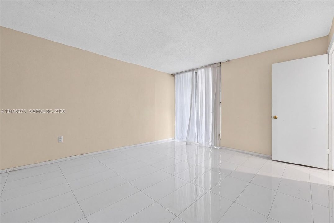 Interior space featuring neutral wall paint, white tile flooring, and a single swing door