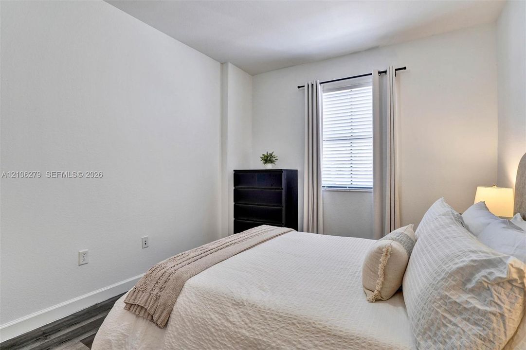 Neutral wall finishes, wood-finish flooring, and a window featuring horizontal blinds