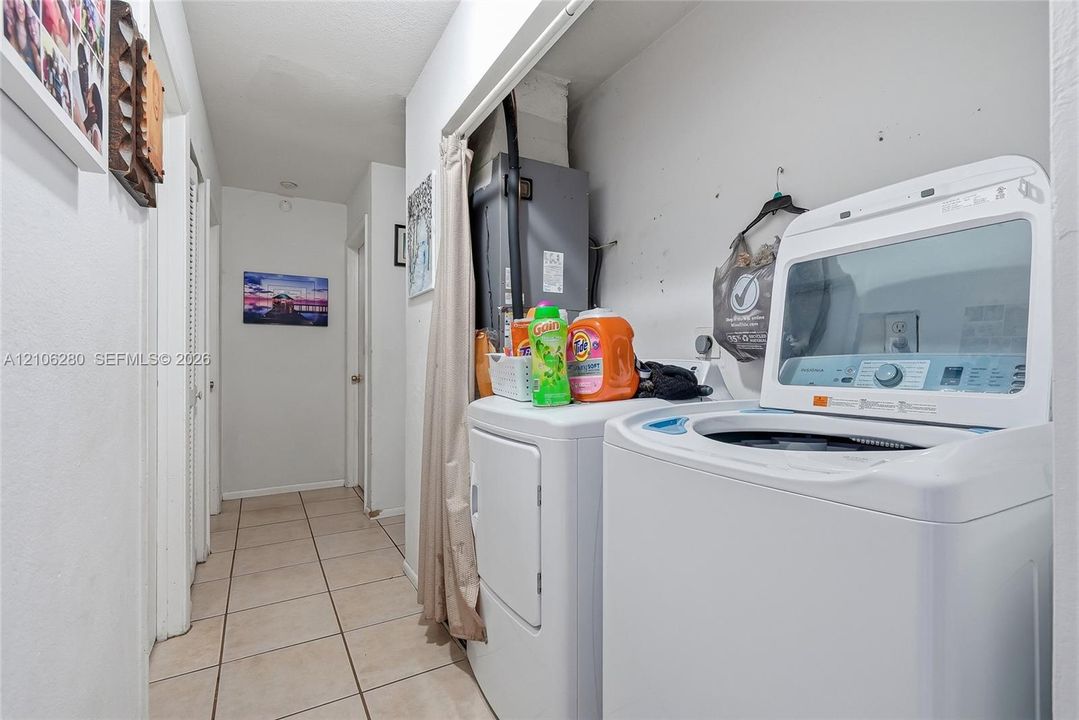 Utility area featuring tile flooring and louvered-panel doors