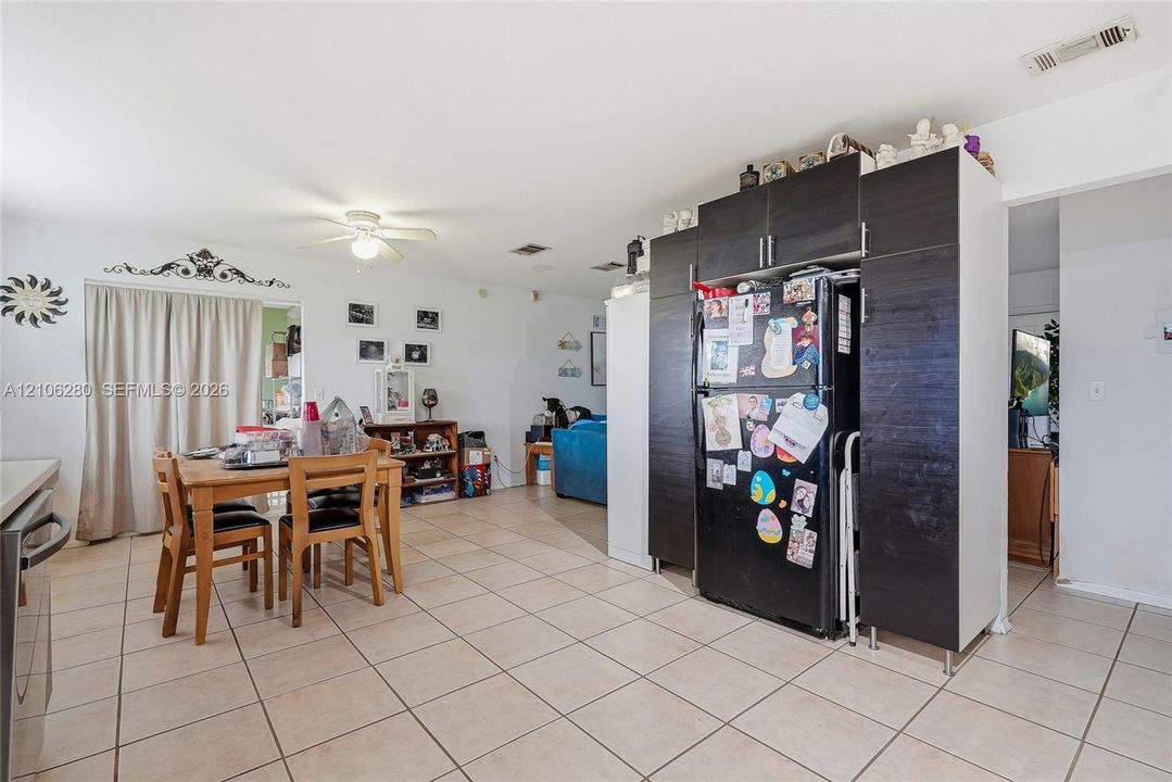 Open-concept area featuring ceramic tile flooring, dark wood-finish cabinetry, and a ceiling-mounted light fixture