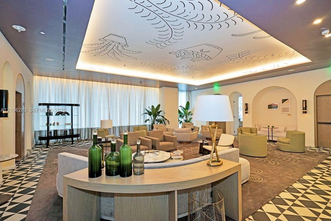 Tray ceiling featuring custom illustrative detailing, recessed lighting, arched wall alcoves, and decorative geometric-patterned flooring