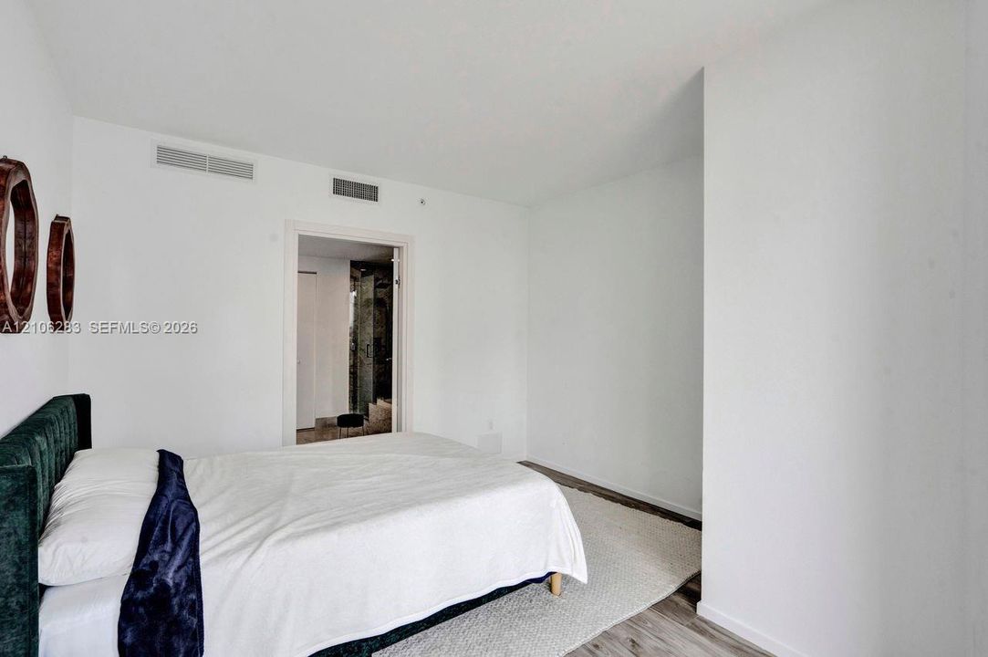 Room featuring white walls and wood-finish flooring