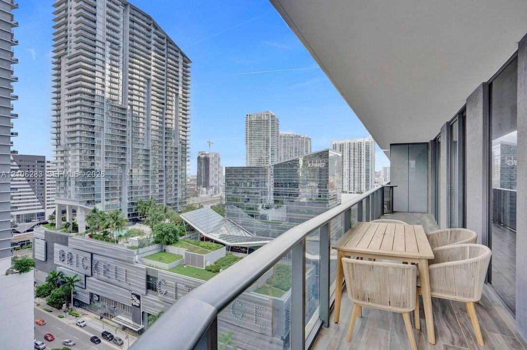 Covered balcony featuring wood-finish flooring and a glass railing