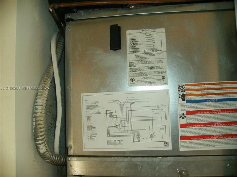 Metal HVAC air handler unit featuring a detailed technical schematic, manufacturer specifications, and safety signage
