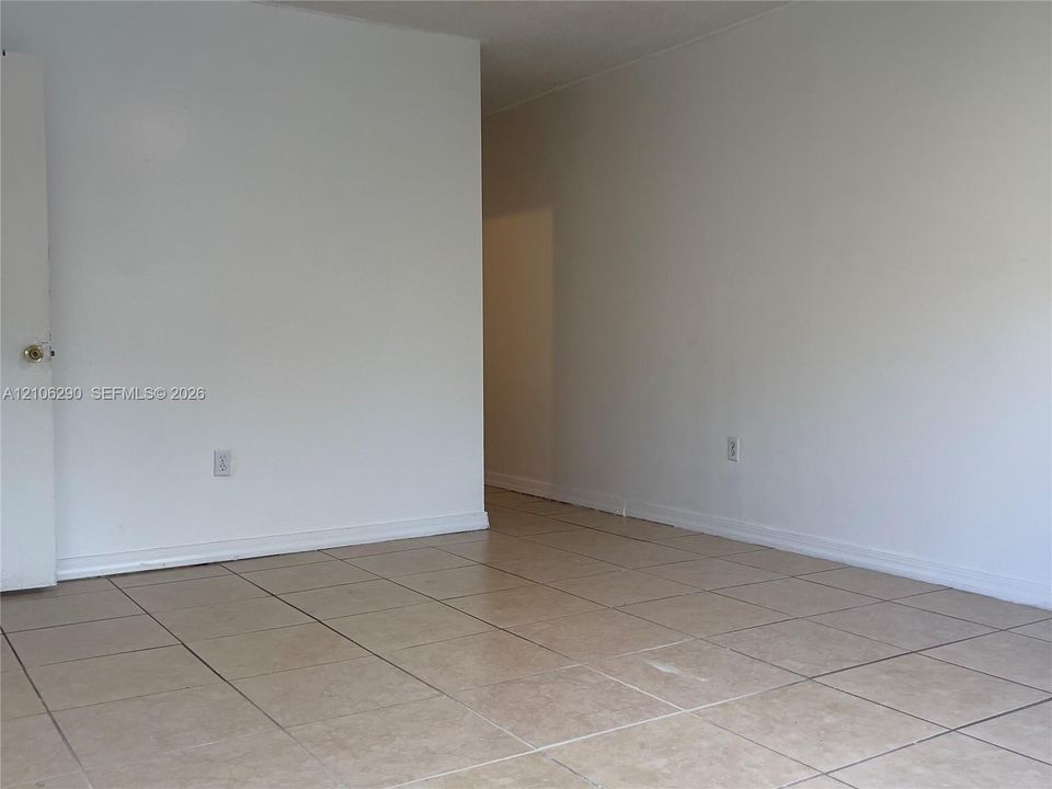 Neutral interior featuring square tile flooring and white walls